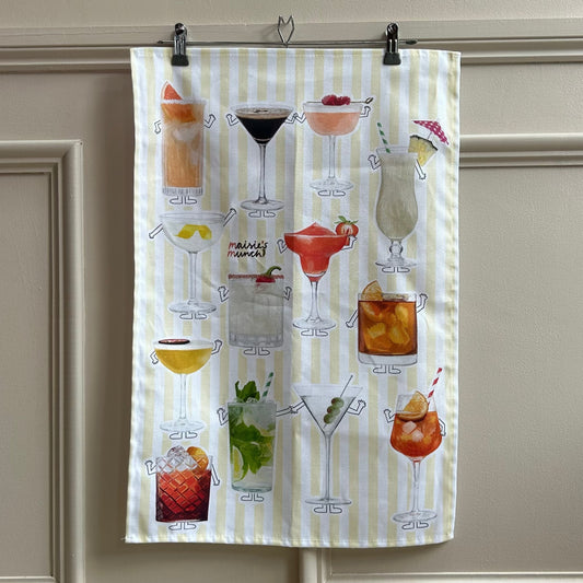 Cocktails tea towel with yellow stripes hanging on a panelled wall